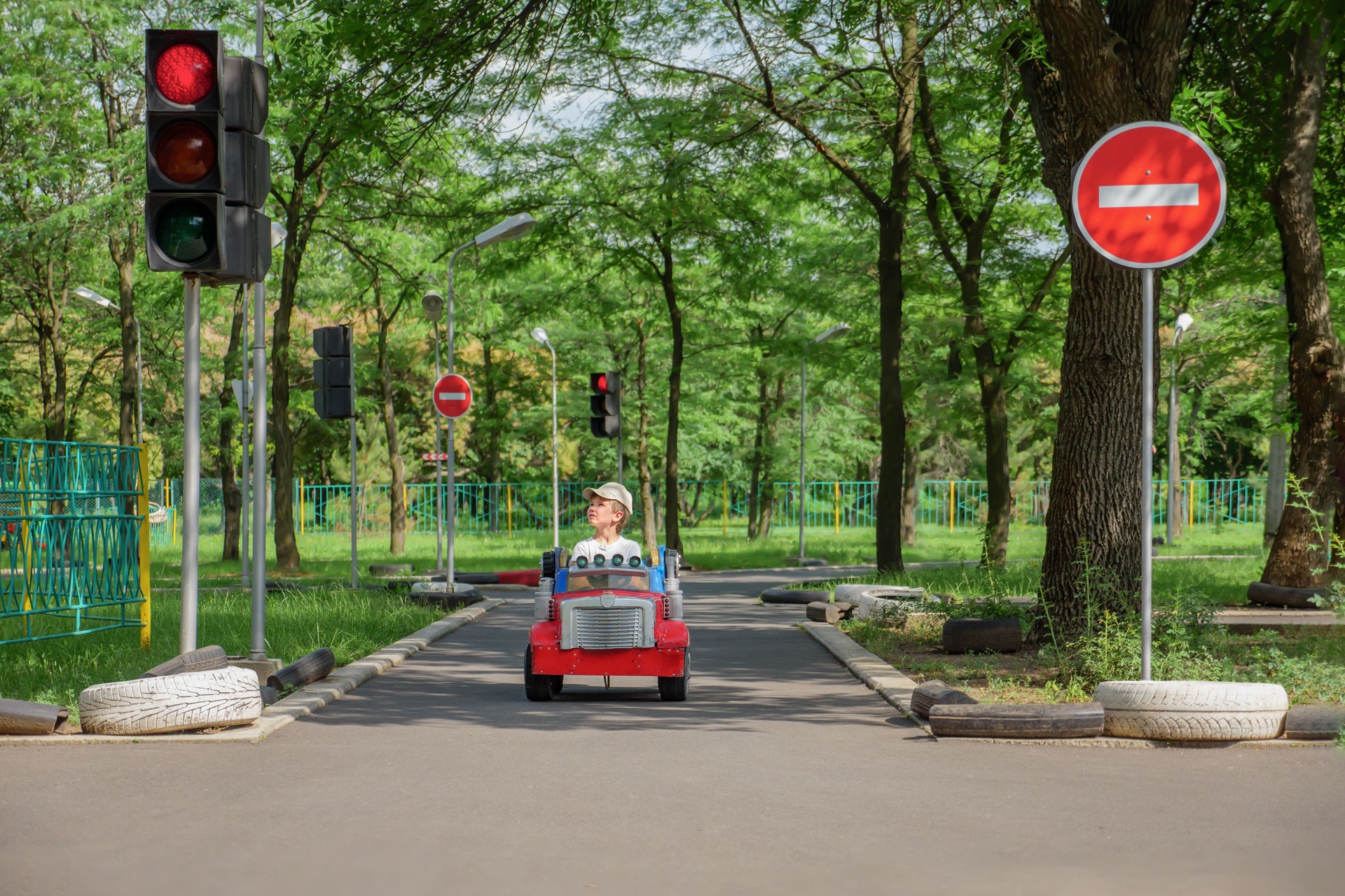 Safety traffic playground. Small boy driving toy car stops at traffic lights on playground child learn traffic rules game road safety education children area. Driving school kids education road rules