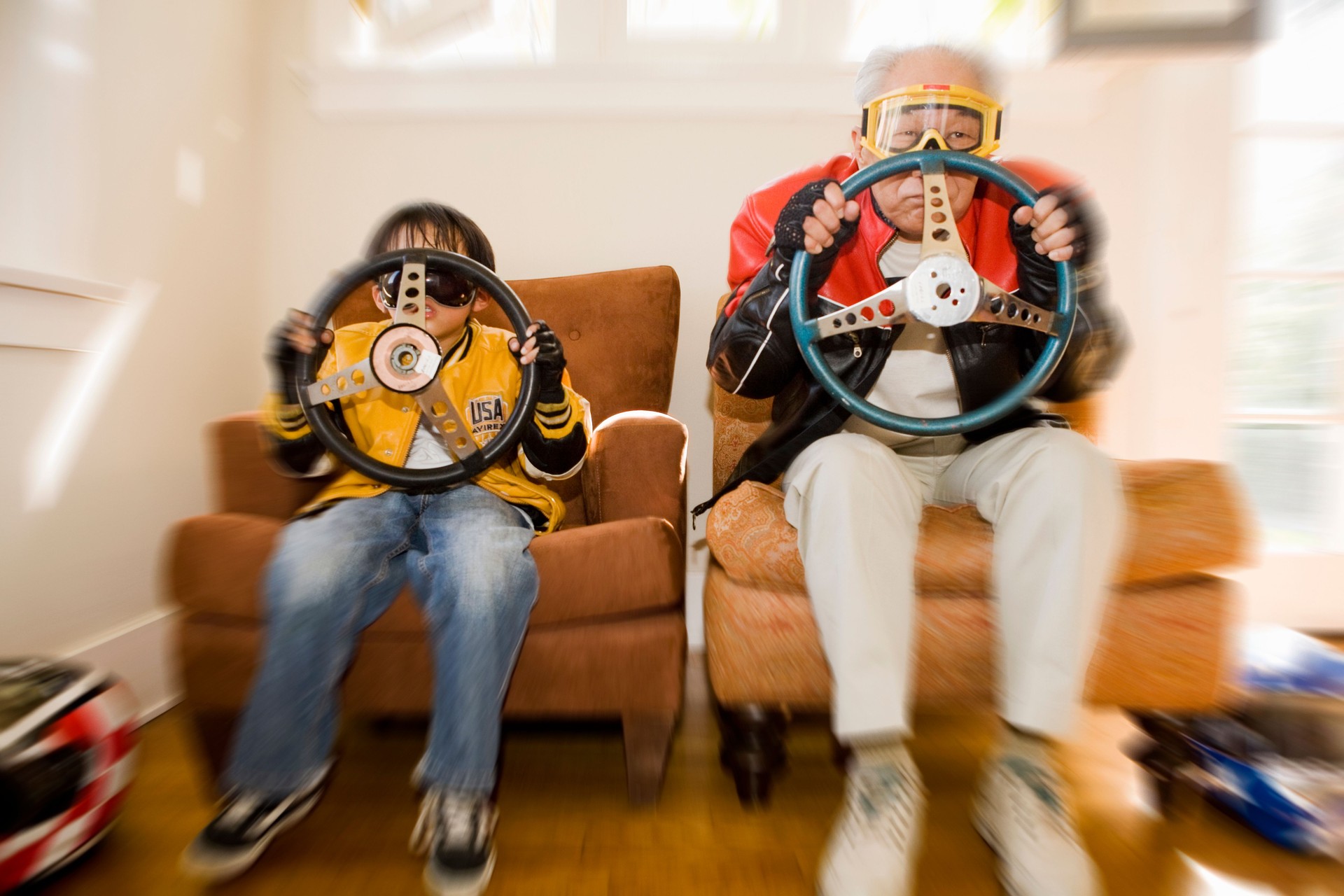 Boy and grandfather holding steering wheels